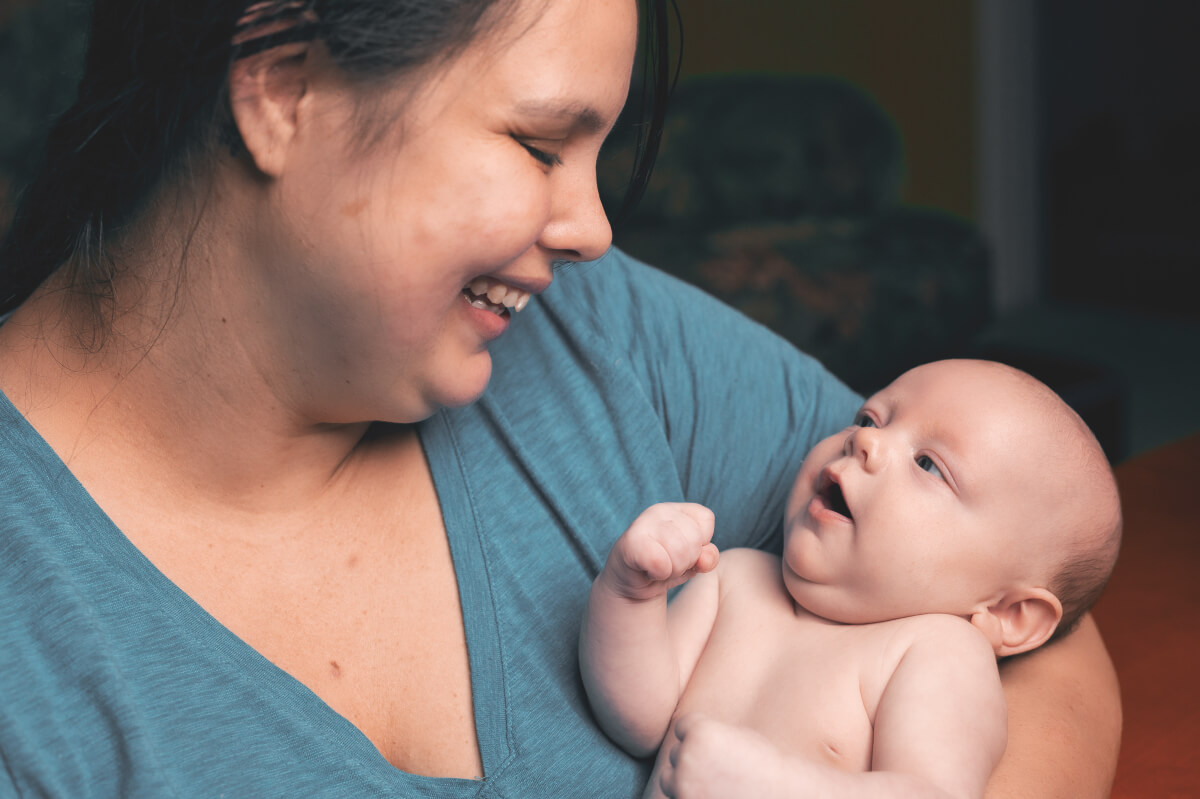 Mom smiling while holding her new born child