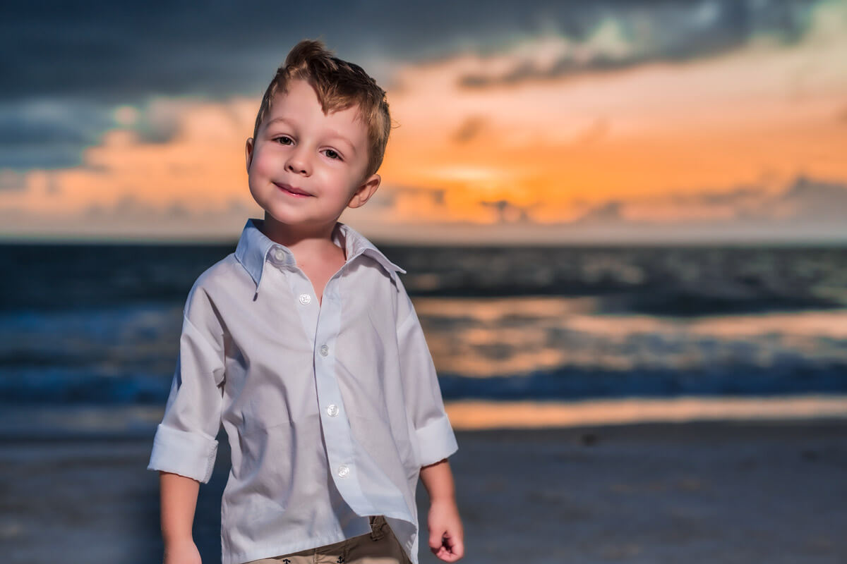 3 year old posing in front the ocean waves